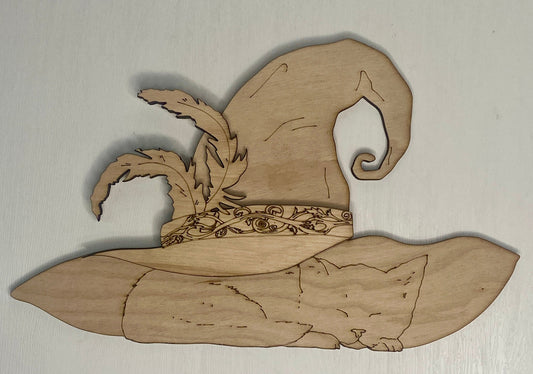 Wooden cutout of a cat in a witch's hat on a light gray background