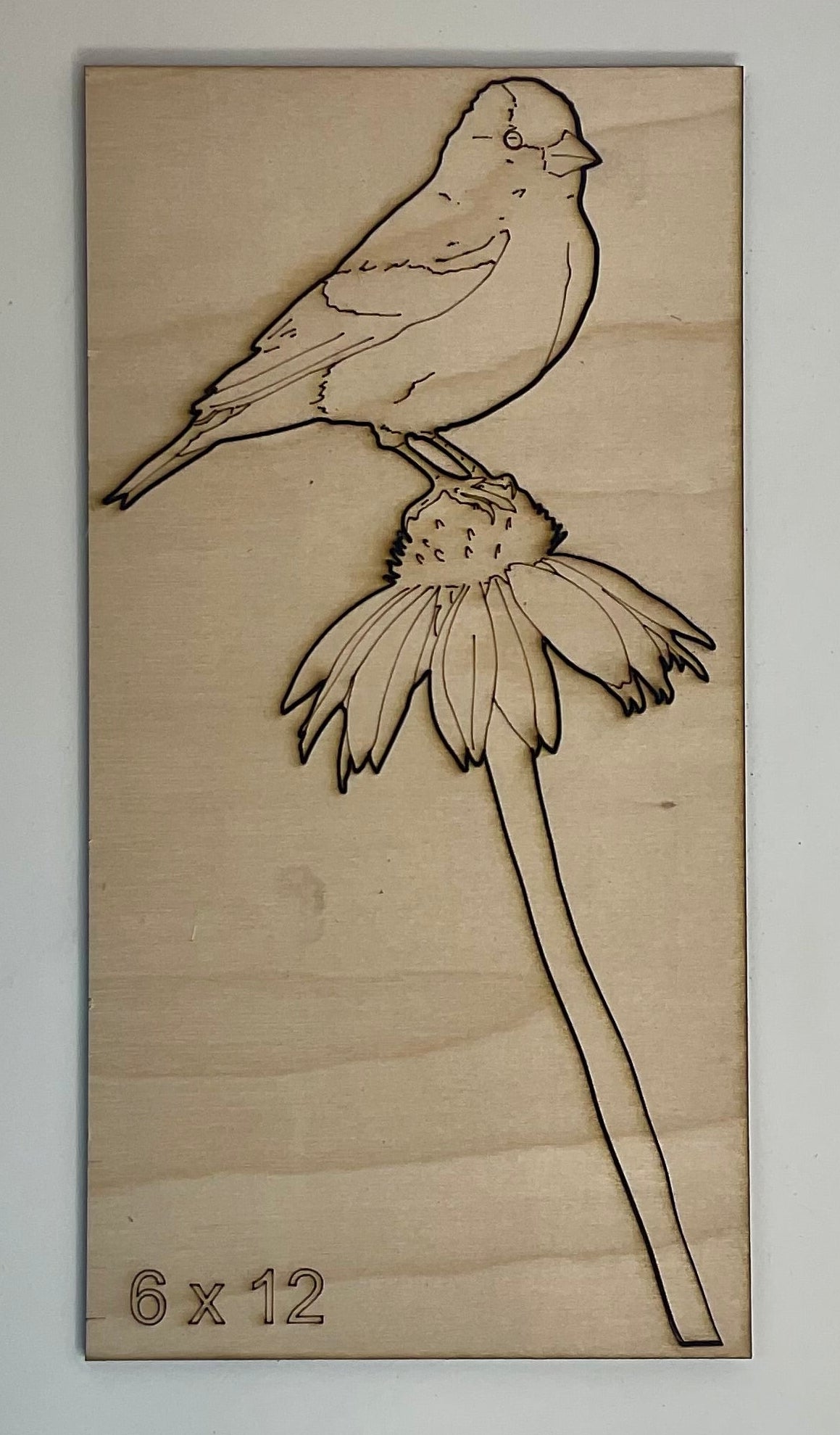 Wooden plaque with laser-cut design of a bird and flower 